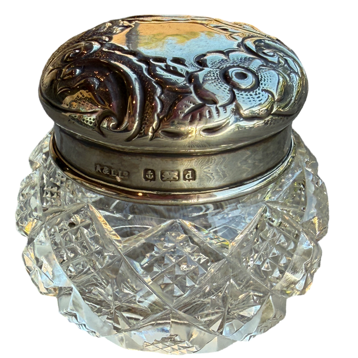 Decorative glass jar with silver lid on a white background