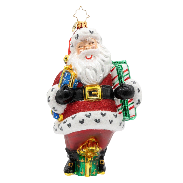 A festive Santa Claus ornament holding wrapped presents, featuring a red and white suit with black trim, a gold belt buckle, and a gold star topper, shown on a plain white background.