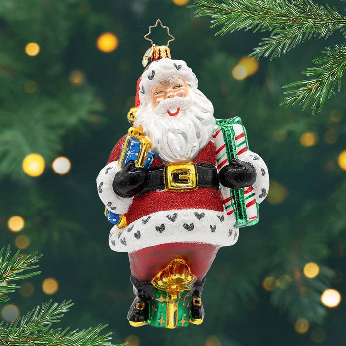 Christopher Radko Jingle & Jolly handcrafted glass Christmas ornament featuring Santa Claus in a red suit with wrapped gifts, peppermint-striped trousers, and glittered holiday details.