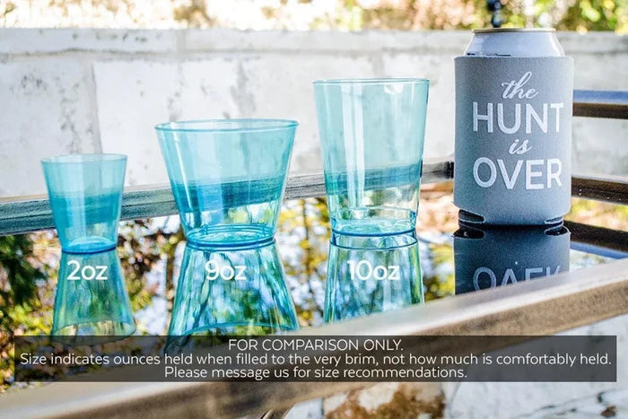 three blue plastic cups and a gray cooler with the text "the hunt is over" on it, placed on a table.