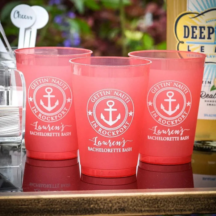 Three pink plastic cups with the text "GETIN'NAUTI IN ROCKPORT" printed on them, along with an anchor symbol, are displayed on a table.