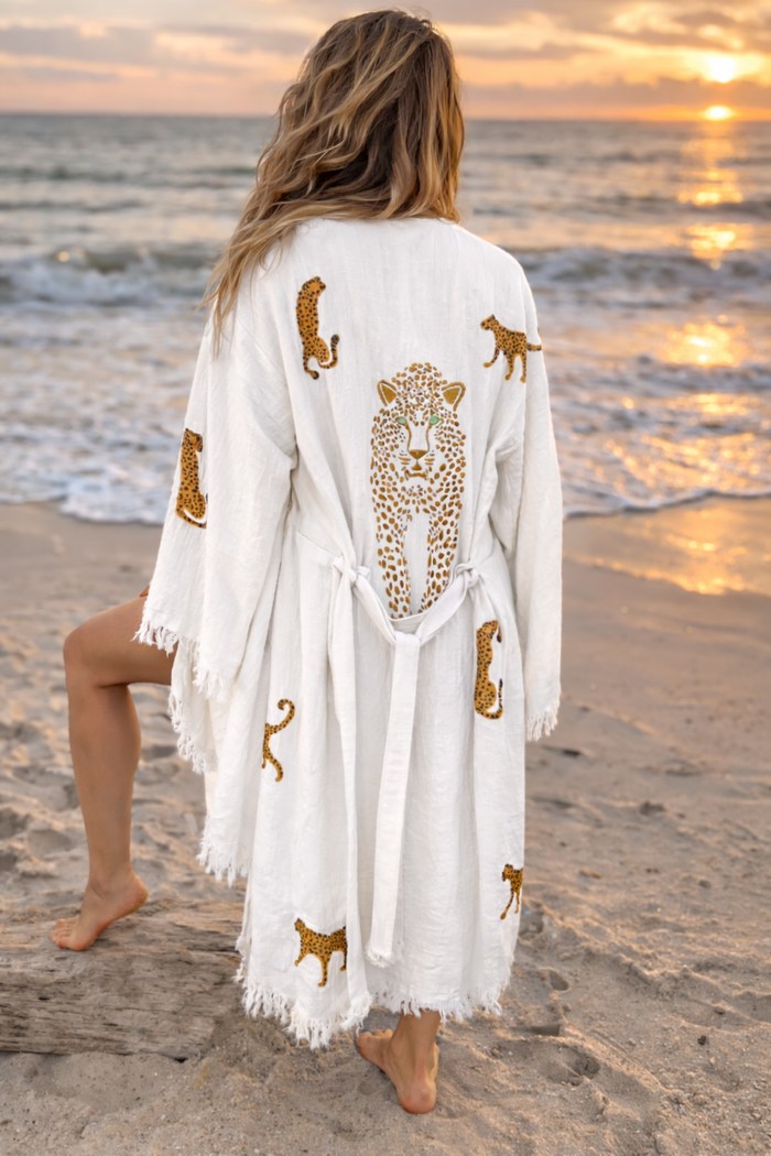 Woman wearing Karli Buxton leopard organic cotton kaftan as a beach cover-up