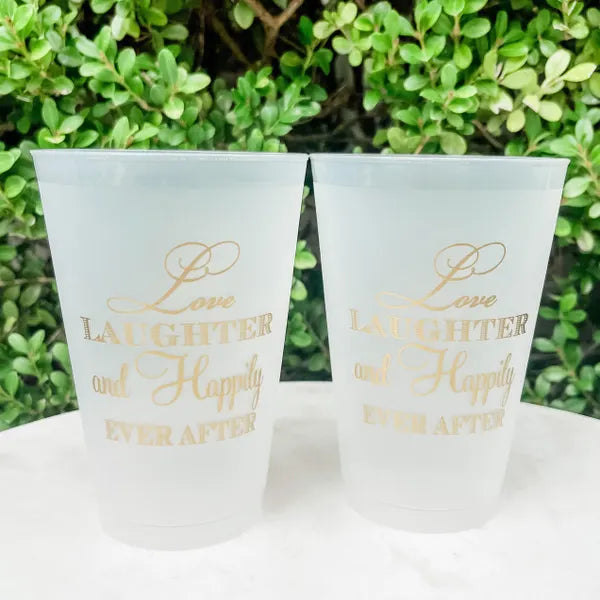Two white foam cups with gold text that says "Love, laughter, and happily ever after".