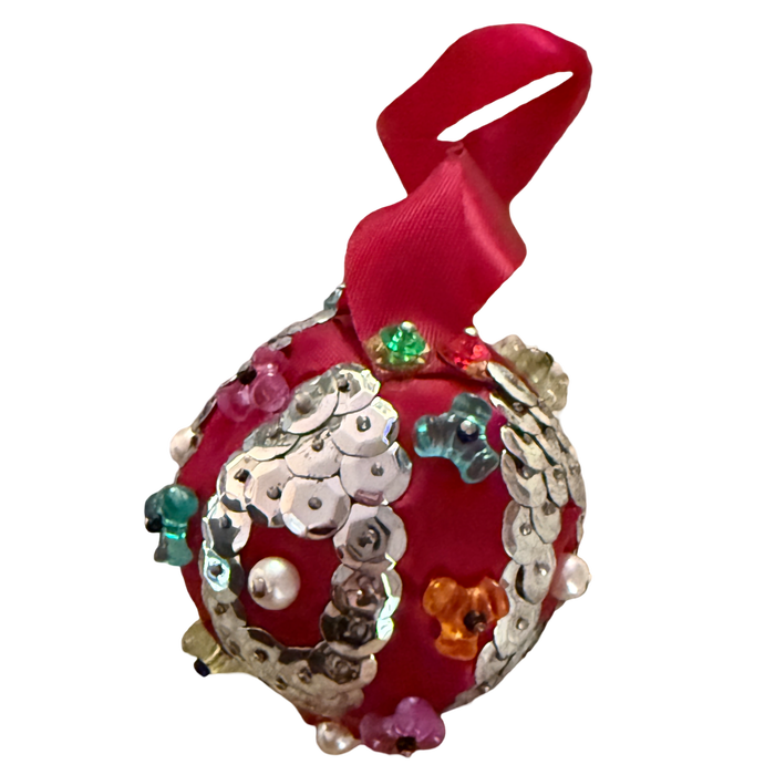 Vintage red satin ornament with oval silver sequin medallions, pearl-look centers, colorful translucent beads, and a red ribbon hanging loop.