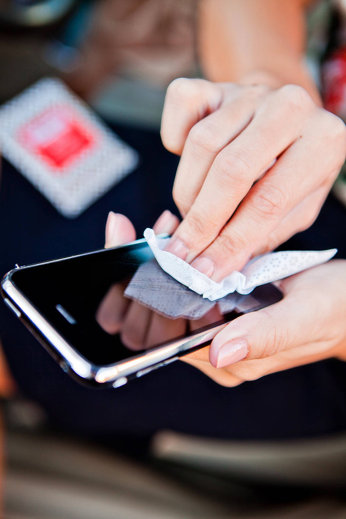 Person cleaning a smartphone screen with a cloth.